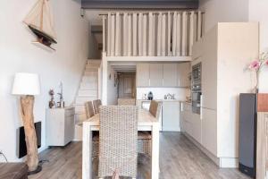 een keuken en eetkamer met een tafel en stoelen bij PERTUIS appartement tout confort in Landrais