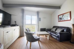 een woonkamer met een bank en een tafel bij PERTUIS appartement tout confort in Landrais