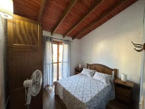 1 dormitorio con 1 cama con ventilador y ventana en casa de playa barra del chuy alborada duplex 2, en Barra del Chuy