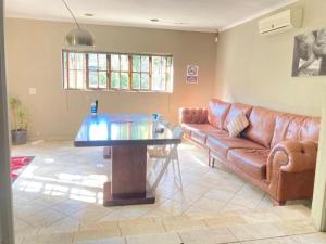 sala de estar con sofá y mesa de cristal en GSpot94 en Johannesburgo