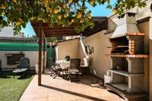 eine Terrasse mit einem Tisch und einem Backofen im Freien in der Unterkunft Cals Avis Casa con Jardín en Banyoles in Banyoles