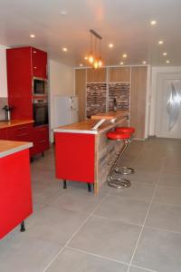 cocina con armarios rojos y taburete de barra roja en Appartement du Pont Monthermé en Monthermé