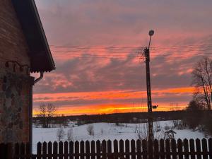 a sunset with a fence and a telephone pole at Stajnia Lipowo 45 in Lipowo