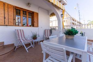 Un patio con una mesa y sillas en un balcón. en rentafive - 8pax - Terraza - 1min playa, en Santa Pola