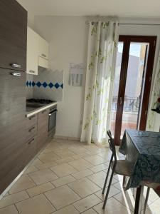 una cucina con tavolo e tavolo e una finestra di Berchida 6 a La Caletta