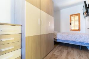 un dormitorio con una cama y un armario en rentafive - 8pax - Terraza - 1min playa, en Santa Pola