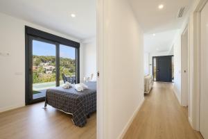 a white room with a bed and a large window at 2Agnes01 in Vidreres