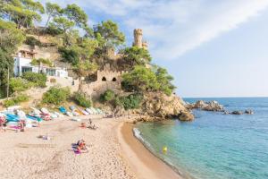 a beach with umbrellas and people on the sand at 2Agnes01 in Vidreres
