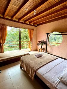 a bedroom with a bed and a large window at Wisdom Forest Lodge in Tena