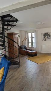 a living room with a couch and a spiral staircase at Maison de charme Isle sur la Sorgue in LʼIsle-sur-la-Sorgue