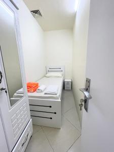 a white bathroom with a sink and a mirror at Premier Serviced Hostel in Dubai