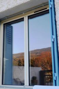 ventana de un edificio con vistas a la montaña en Au Bregnat Vue du mont Ventoux, en Bédoin