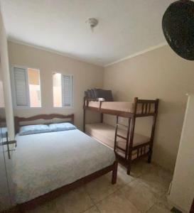 a bedroom with a bed and a desk and a table at Casa Praia Temporada Itanhaém in Itanhaém