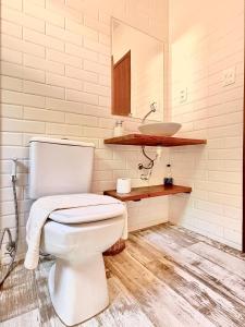 uma casa de banho com um WC branco e um lavatório. em Casa Hibiscus na Ilha de Boipeba