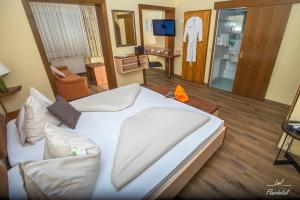 a hotel room with a large bed and a bathroom at Flairhotel am Wörthersee in Schiefling am See