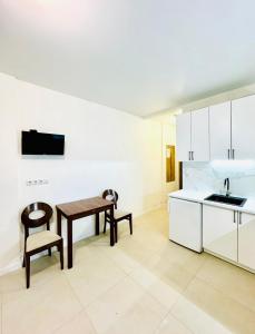 a kitchen with a wooden table and a sink at Тут светло и уютно in Kyiv