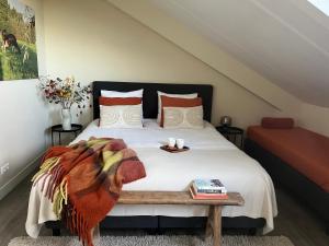 een slaapkamer met een bed en een tafel met boeken bij @TheLodge 