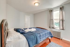 a bedroom with a bed with a blue blanket and a window at Convenient Newark Home about 2 Mi to Downtown! in Newark