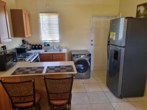 a kitchen with a refrigerator and a washer and dryer at Charming 2-Bed House in Portmore gated community in Portmore