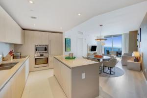 哈蘭代爾海灘的住宿－2 BR Beach condo ocean views at Hyde MIiami，厨房、带桌子的客厅和用餐室