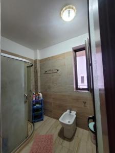 uma casa de banho com um chuveiro, um WC e um lavatório. em Guesthouse Kocibelli em Korçë