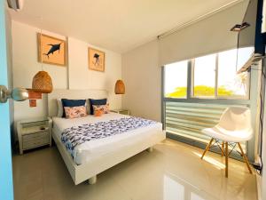 a bedroom with a bed and a chair in it at GIO Hotel Tama Santa Marta in Santa Marta