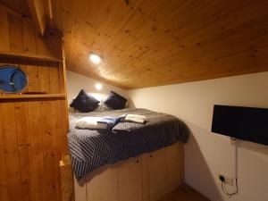 a small bedroom with a bed in a room with wooden ceilings at Fern Cottage Annexe in Croyde