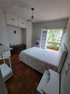 Un dormitorio con una cama grande y una ventana en Casa Pé na Areia Cantão do Bora Bora - Manaaki Surf Hostel en São Sebastião
