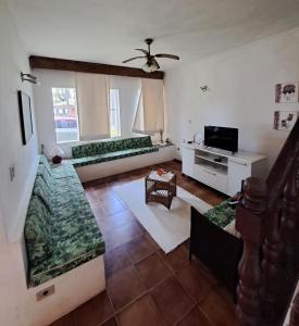 Sala de estar con 2 sofás y TV en Casa Pé na Areia Cantão do Bora Bora - Manaaki Surf Hostel, en São Sebastião
