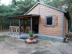 a log cabin with a porch and a patio at Świetna Chatka nad jeziorem in Świętne