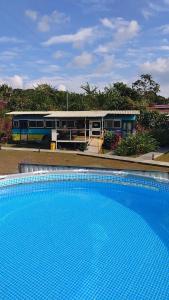 una gran piscina azul frente a un tren en Dreamcatcher House Bus Experience 2 en Sarchí