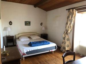 una camera con letto, scrivania e finestra di Maison typique/SPA/ Wifi/20 min plage a La Jonchère