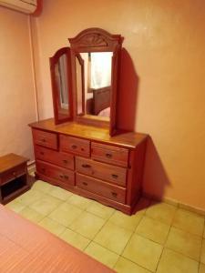 ein Schlafzimmer mit einer Kommode mit einem Spiegel darauf in der Unterkunft Vacances agréables c'est ici in Les Abymes