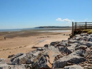 a beach with large rocks on a sandy beach at Barn Owl in Clatworthy
