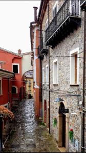 un callejón de piedra con edificios y una sombrilla en Casa vacanze da Linda en Pignola