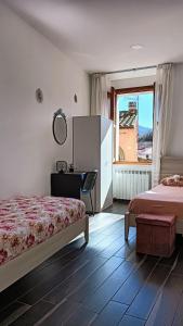 a bedroom with two beds and a desk and a window at Casa vacanze da Linda in Pignola