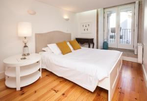 Dormitorio blanco con cama blanca y mesa en ChillHouse_Porto en Oporto