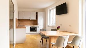 奧格斯堡的住宿－Henrys Sleeping am Augsburger Eiskanal，厨房以及带木桌和椅子的用餐室。