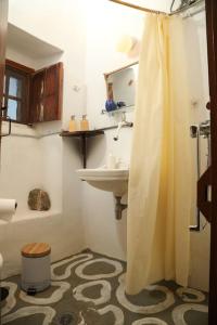a bathroom with a sink and a shower curtain at Tower of Dellarokas in Mélanes