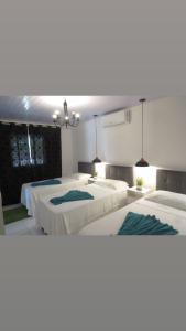 2 camas en una habitación grande con 2 camas individuales en Granja Dona Dora, en Nísia Floresta