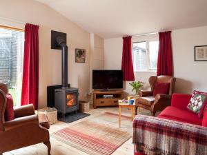 a living room with a fireplace and red curtains at 2 bed in Ashford 49685 in Egerton