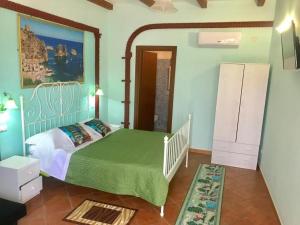 ein Schlafzimmer mit einem Bett mit einer grünen Bettdecke in der Unterkunft B&B Teodora in Gaggi