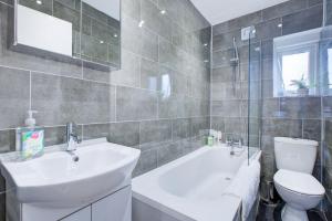 a bathroom with a sink and a toilet and a tub at Wonderful Two-Bedroom Apartment in London