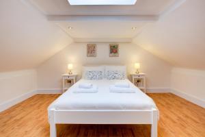 a bedroom with a large white bed with two lamps at Wonderful Two-Bedroom Apartment in London