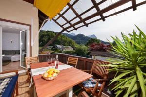 a wooden table with a bowl of fruit on a balcony at Apartment Sir George in Garmisch-Partenkirchen