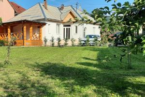 a house with a grass yard in front of it at Mura House in Vişeu de Sus