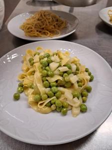 a plate of food with peas and pasta on a table at Country House Bucaneve in Rovolon