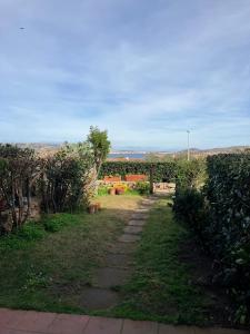 Un camino a través de un jardín con bancos y árboles. en Casetta Spinnaker, en Palau 17 fotos más