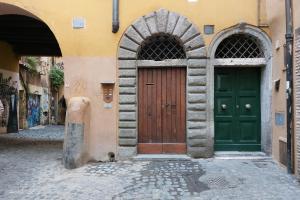 un edificio con dos puertas verdes en una calle en St.Margherita Charming House, en Roma