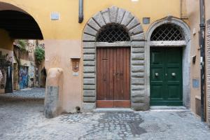 ローマにあるSt.Margherita Charming Houseの通りに緑の扉が2つある建物